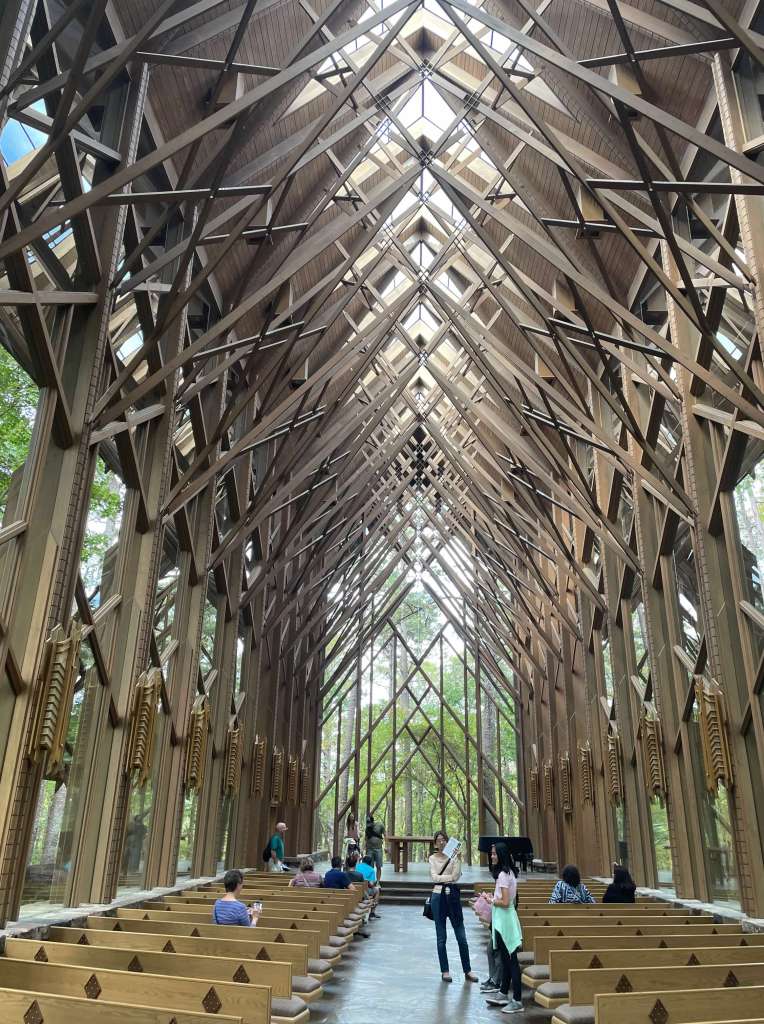 Interior view of the Anthony Chapel at Garvan Woodland Gardens, showcasing its wooden structure and large windows that invite natural light.